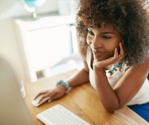 Smiling woman using a PCs for People refurbished desktop computer